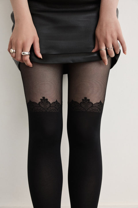 Close-up of Rachel's Lace Crown Over-the-Knee Tights in Black, showing the lace pattern at the top of the thigh.